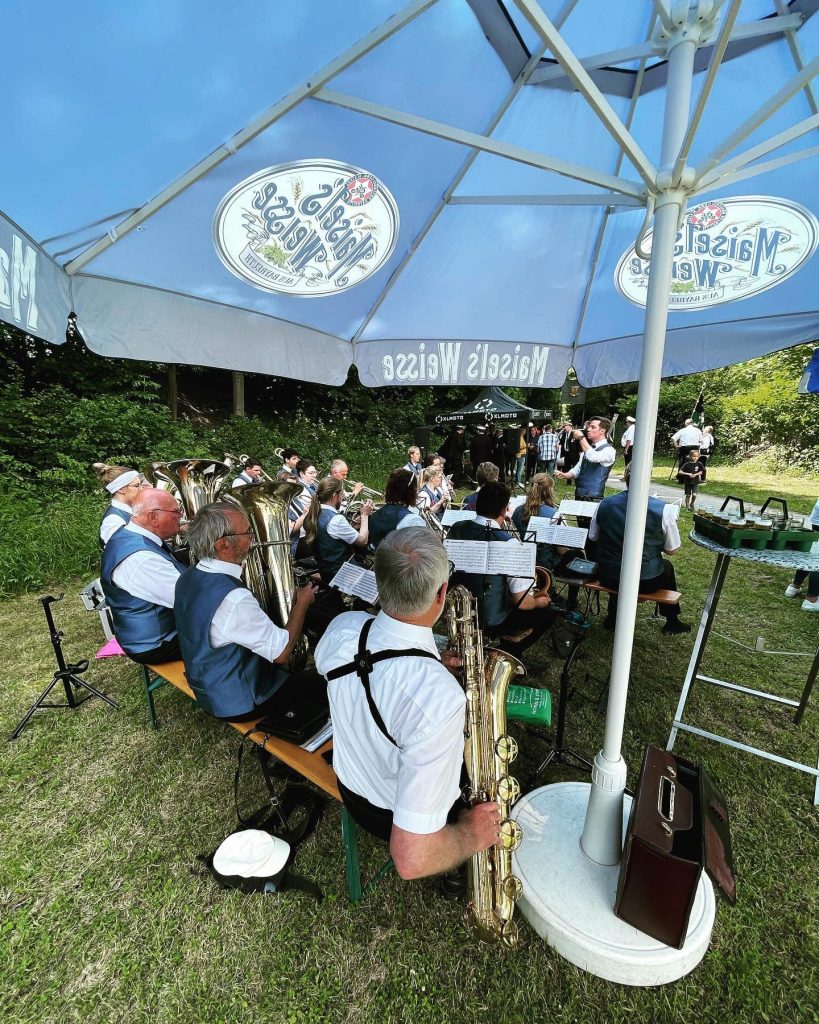 Musiker in Uniform unter einem Sonnenschirm beim Sommerfest des GVU Hüsten 2022