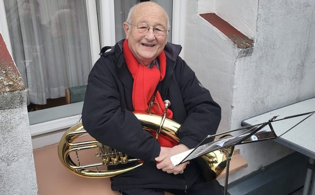 Ein älterer Musiker mit Tenorhorn lächelt beim Weihnachtsständchen, Weihnachten 2022