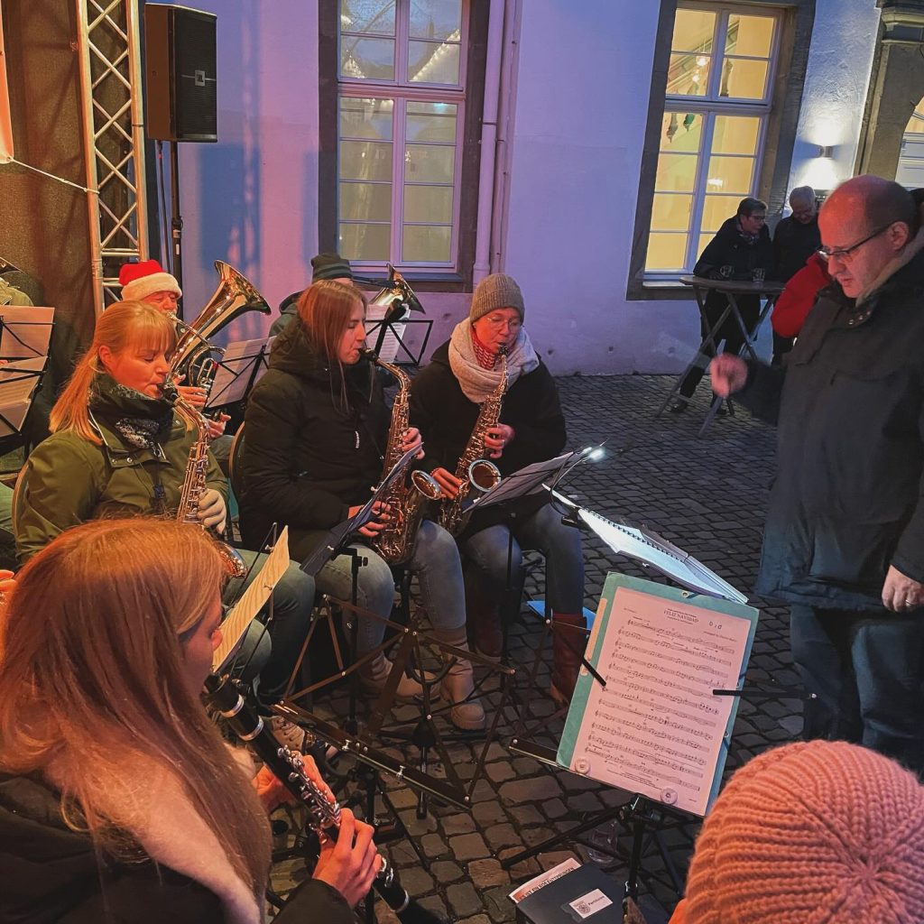 Der Dirigent leitet das Orchester am Abend auf dem Weihnachtsmarkt 2023