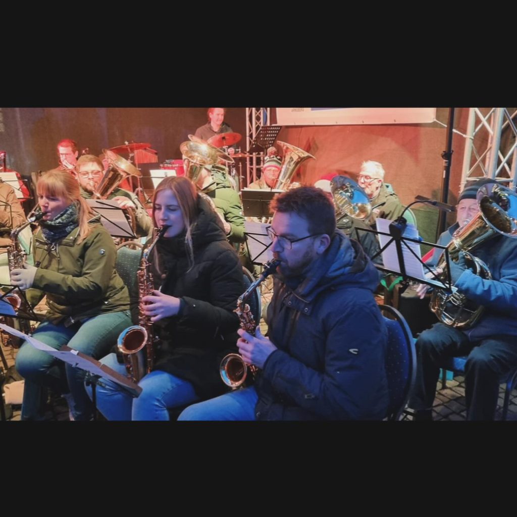 Saxophonisten in Winterjacken auf der Weihnachtsmarktbühne 2023