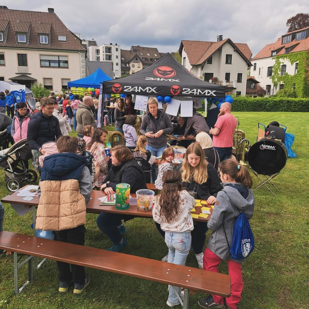 Kinder an Basteltischen auf der Wiese beim Kids Day 2024