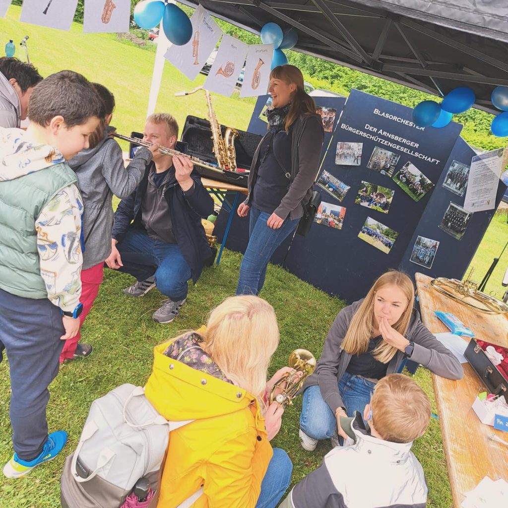 Kinder probieren am Stand des Blasorchesters Instrumente aus, Kids Day 2024
