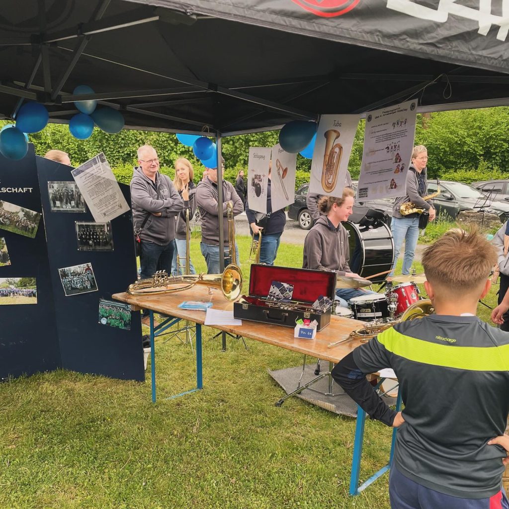 Infostand des Blasorchesters mit Instrumenten im Pavillon beim Kids Day 2024