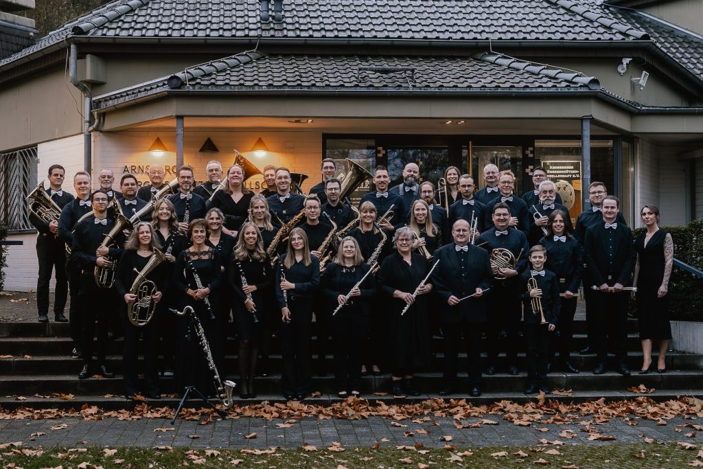 Gruppenfoto des Blasorchesters vor der Festhalle am Tag des Herbstkonzerts 2025