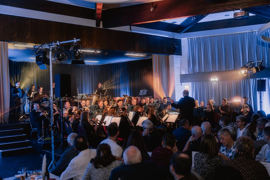 Das Blasorchester spielt in der vollbesetzten Festhalle, Blick über das Publikum zur Bühne