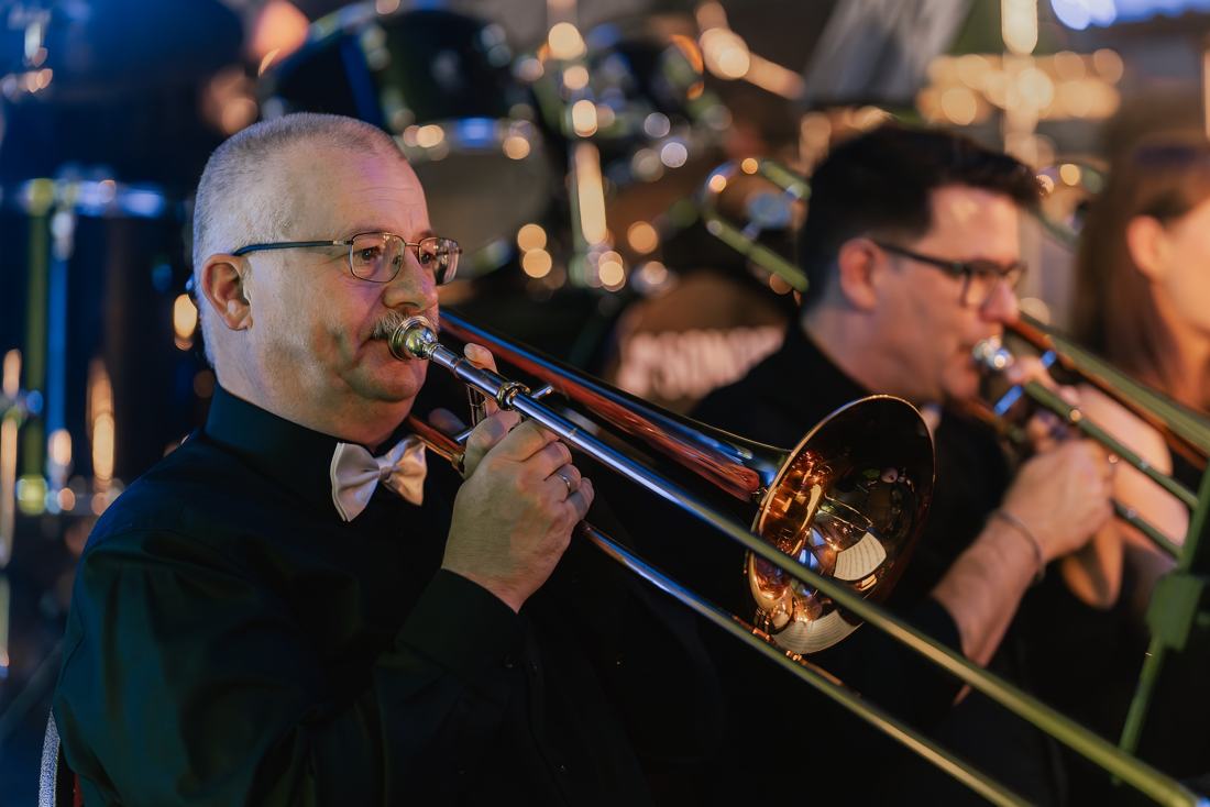 Posaunisten des Blasorchesters spielen bei einem Konzert